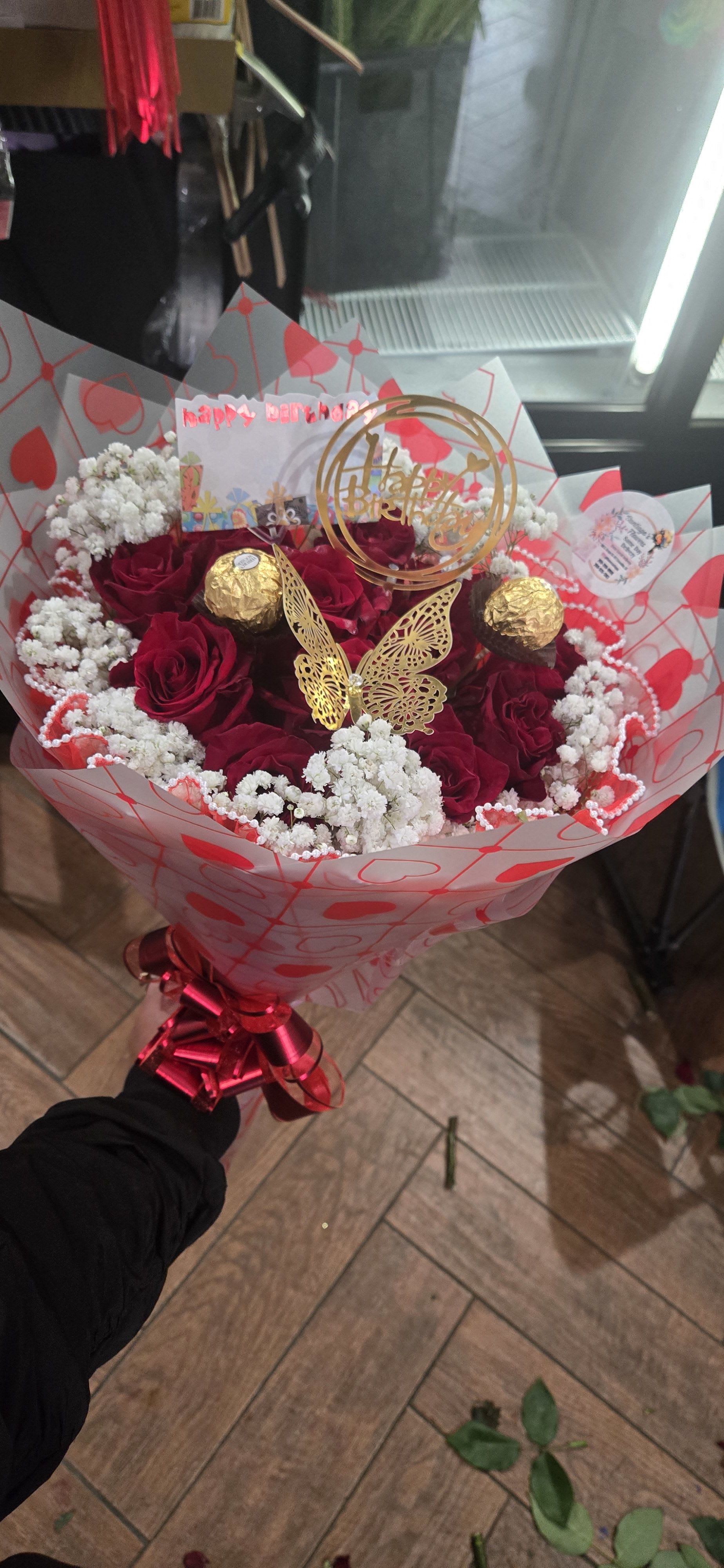 Bouquet of red roses with white baby's breath and gold decorations