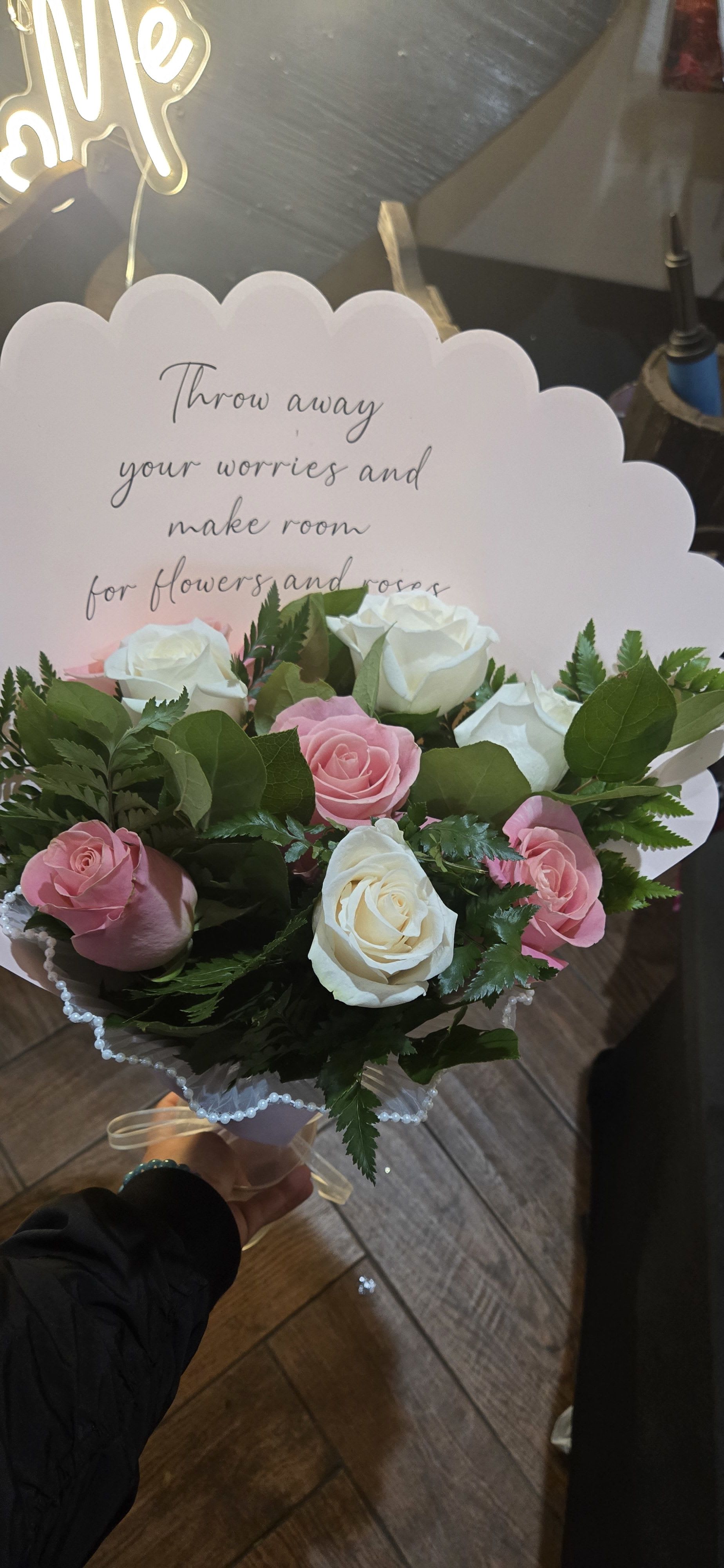 Bouquet of pink and white roses with a scalloped card