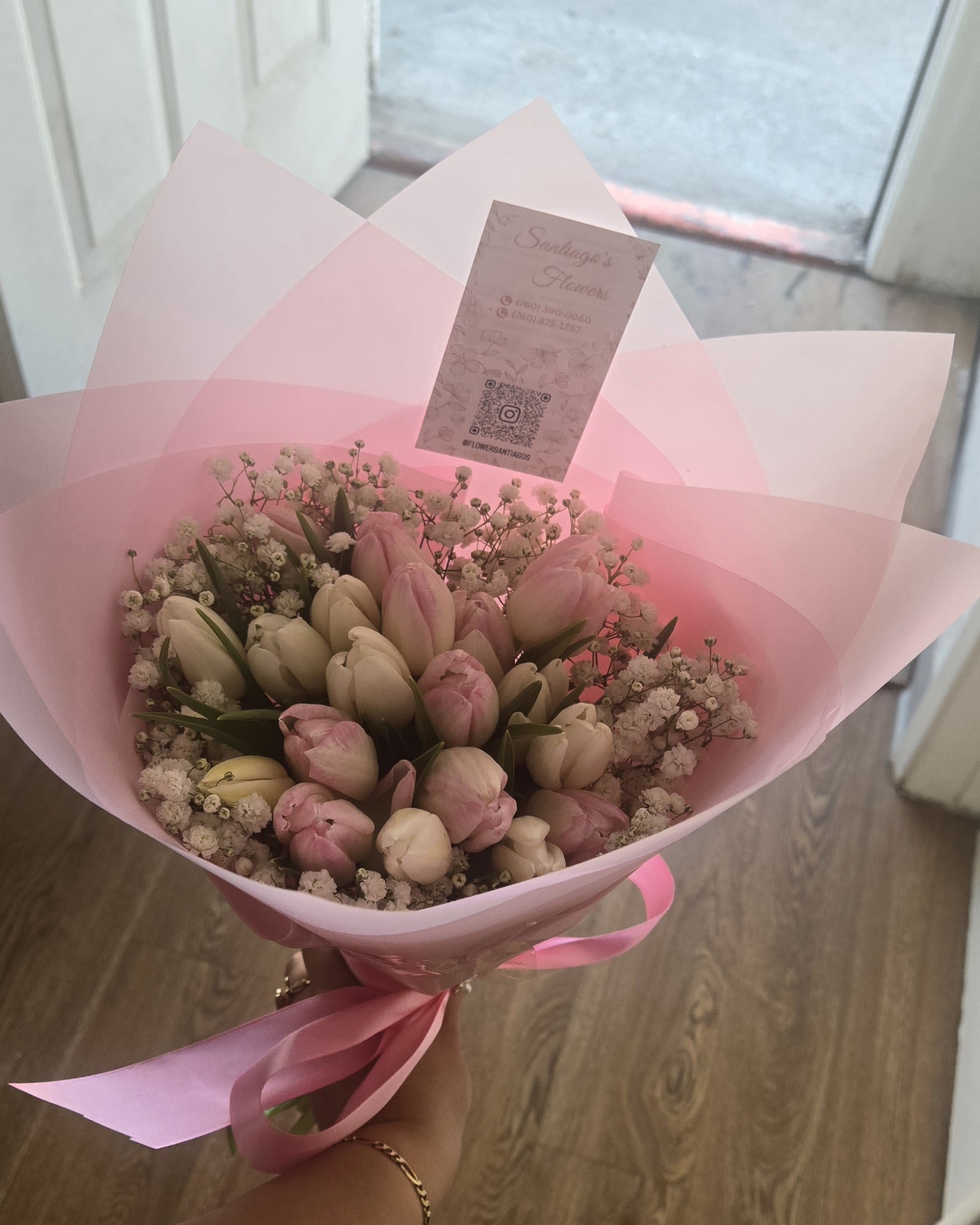 Pink and white tulip bouquet wrapped in pink paper with a ribbon