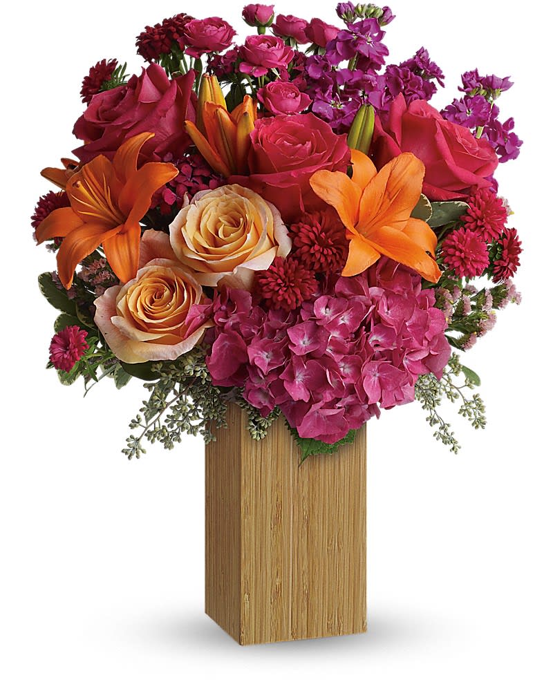 Teleflora's Fuchsia Fantasy - Fabulous! Hot pink flowers are mixed with sunny orange blooms to warm her heart and tickle her fancy. Perfect for birthdays -or any day you want to make her feel extra special. This fantastic floral arrangement includes full pink hydrangea, peach and hot pink roses, orange asiatic lilies, purple stock, hot pink matsumoto asters, raspberry-hued statice and dark pink sweet william with seeded eucalyptus and variegated pittosporum to add fresh green hues. Delivered in a sleek bamboo vase.