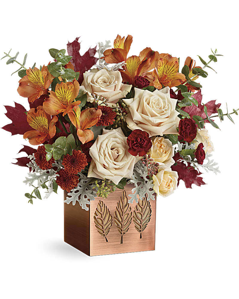 Teleflora's Shimmering Leaves Bouquet - This elegant fall rose bouquet, artistically arranged in a copper-plated cube with punched leaf motif, will warm their hearts and table! A simple votive later transforms the cube into a glowing candleholder. This lush bouquet features crÃ¨me roses, peach spray roses, orange alstroemeria, maroon miniature carnations, brown button spray chrysanthemums, dusty miller, spiral eucalyptus, seeded eucalyptus, and brown transparent oak leaves. Delivered in a Copper Petals Cube.