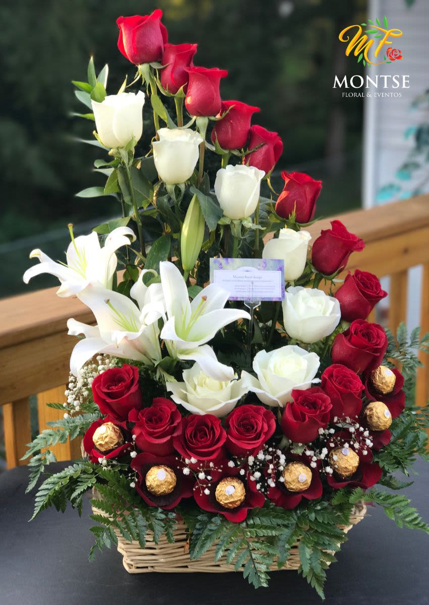 Basket arrangement of red and white roses with white lilies and gold chocolates