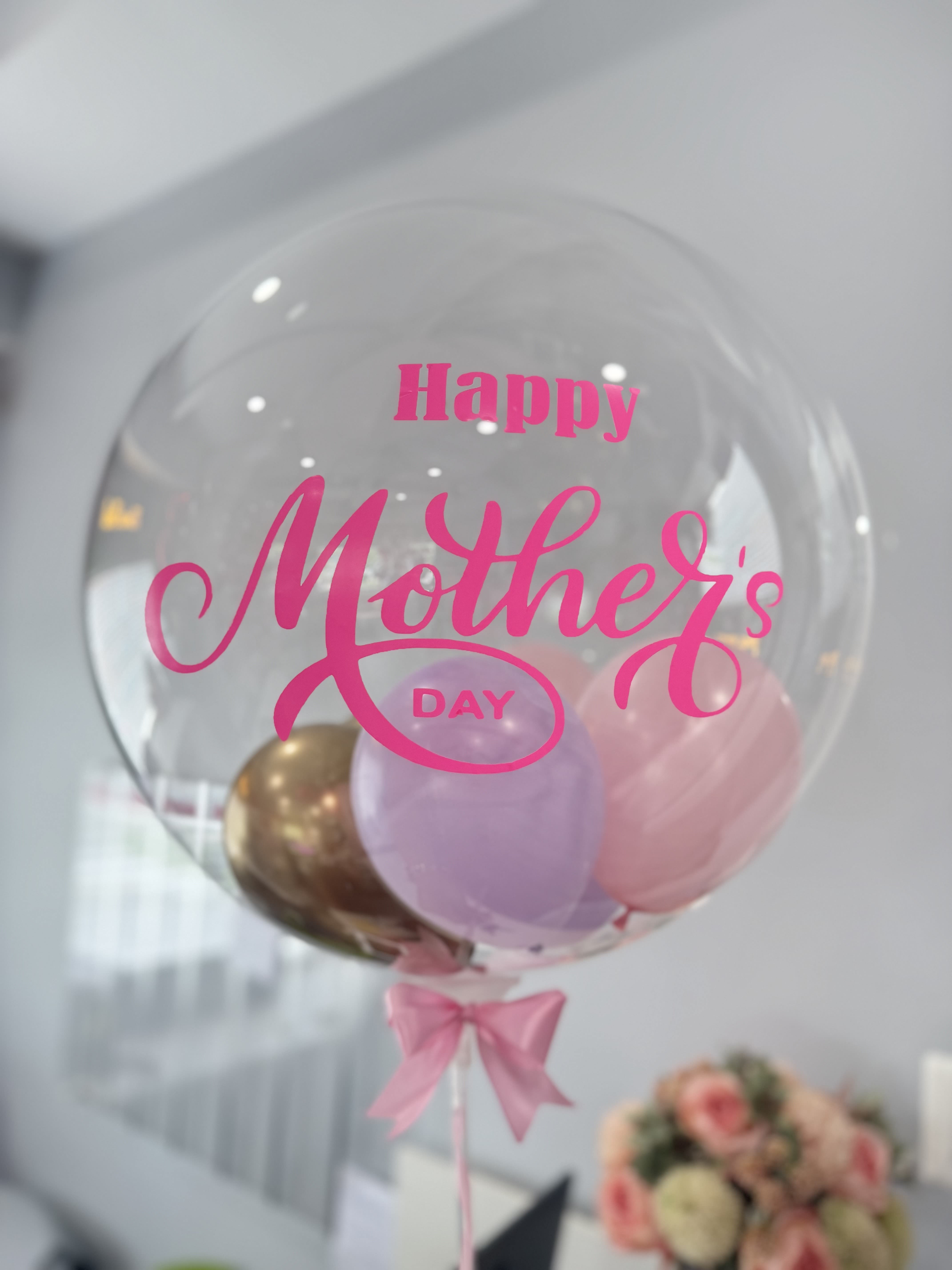 Clear balloon with pink "Happy Mother's Day" text and pastel balloons inside
