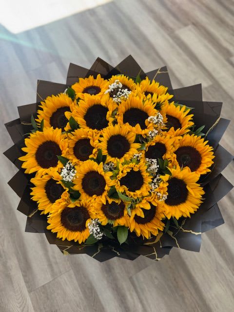 Bouquet of sunflowers wrapped in dark paper