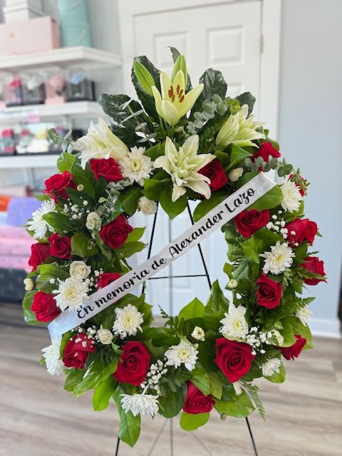 Floral sympathy wreath with red roses and white lilies on a stand