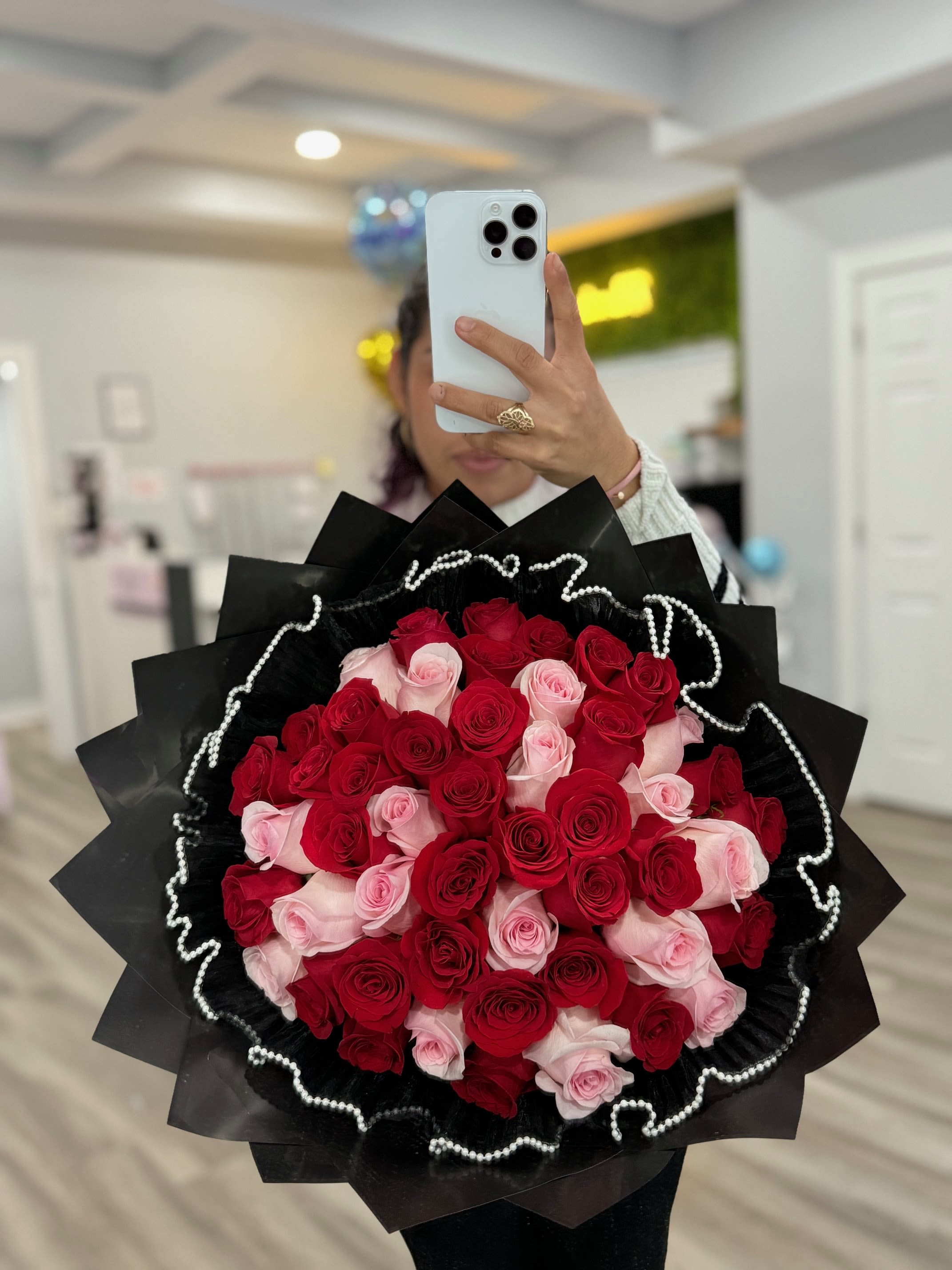 Large bouquet of red and pink roses wrapped in black paper