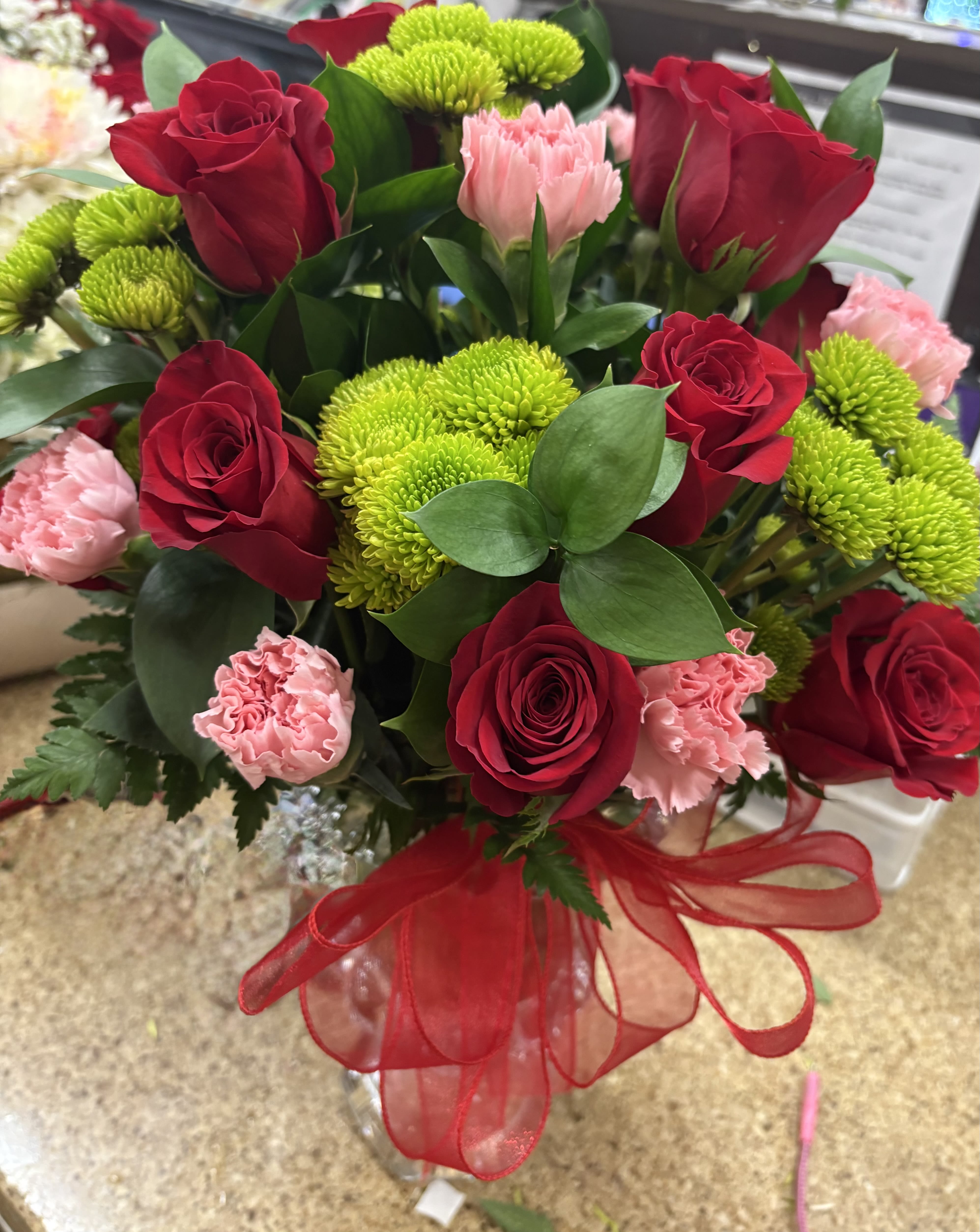 Red and pink beauty - dozen red roses green poms and light pink carnations 