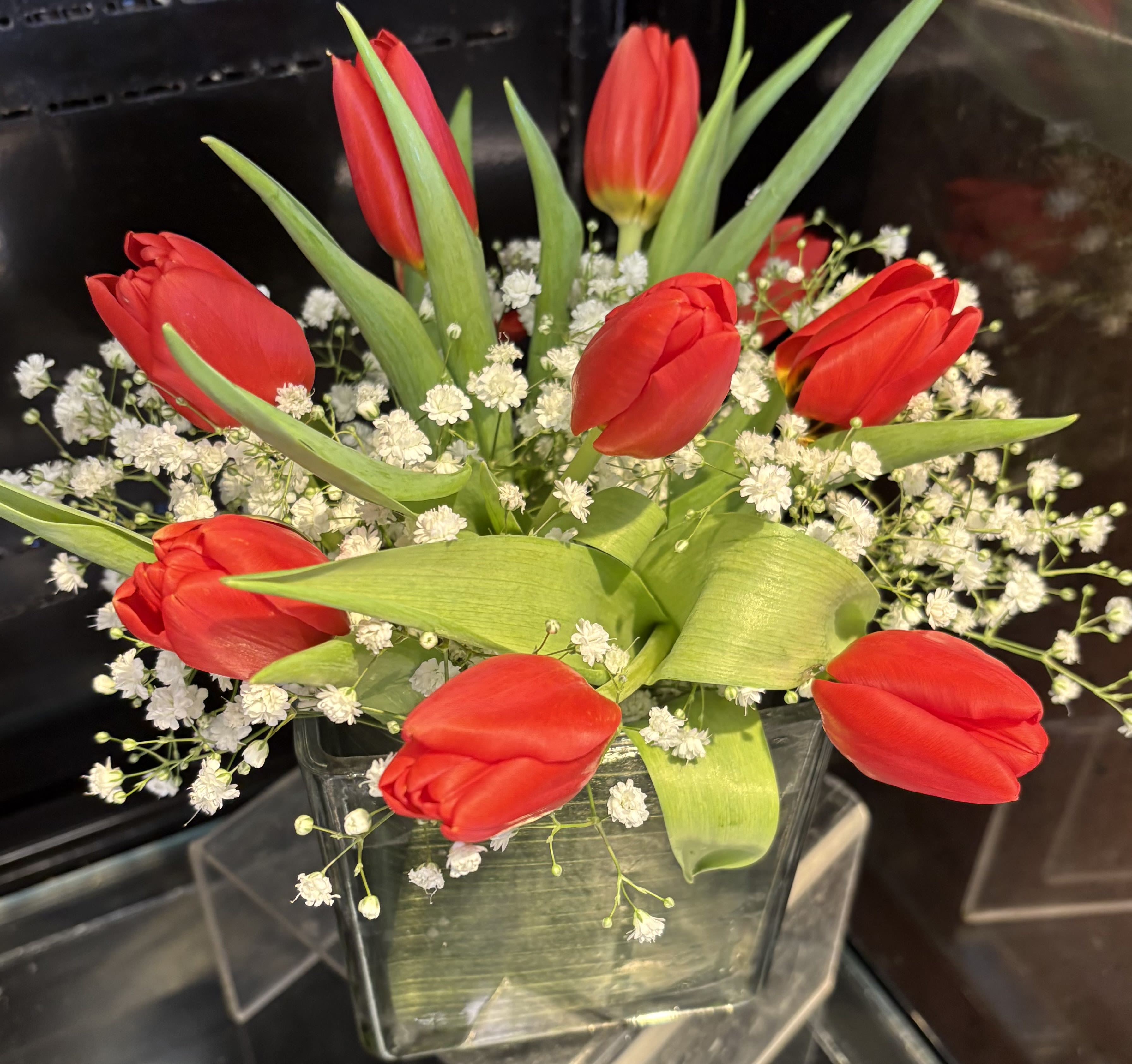 Happy tulips - bright orange tulips on a short vase with baby’s breath.