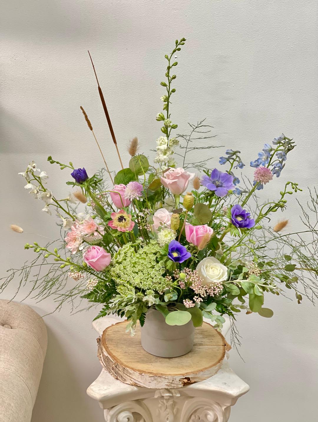 Loose pastel bouquet in a white vase with pink, purple, and white blooms