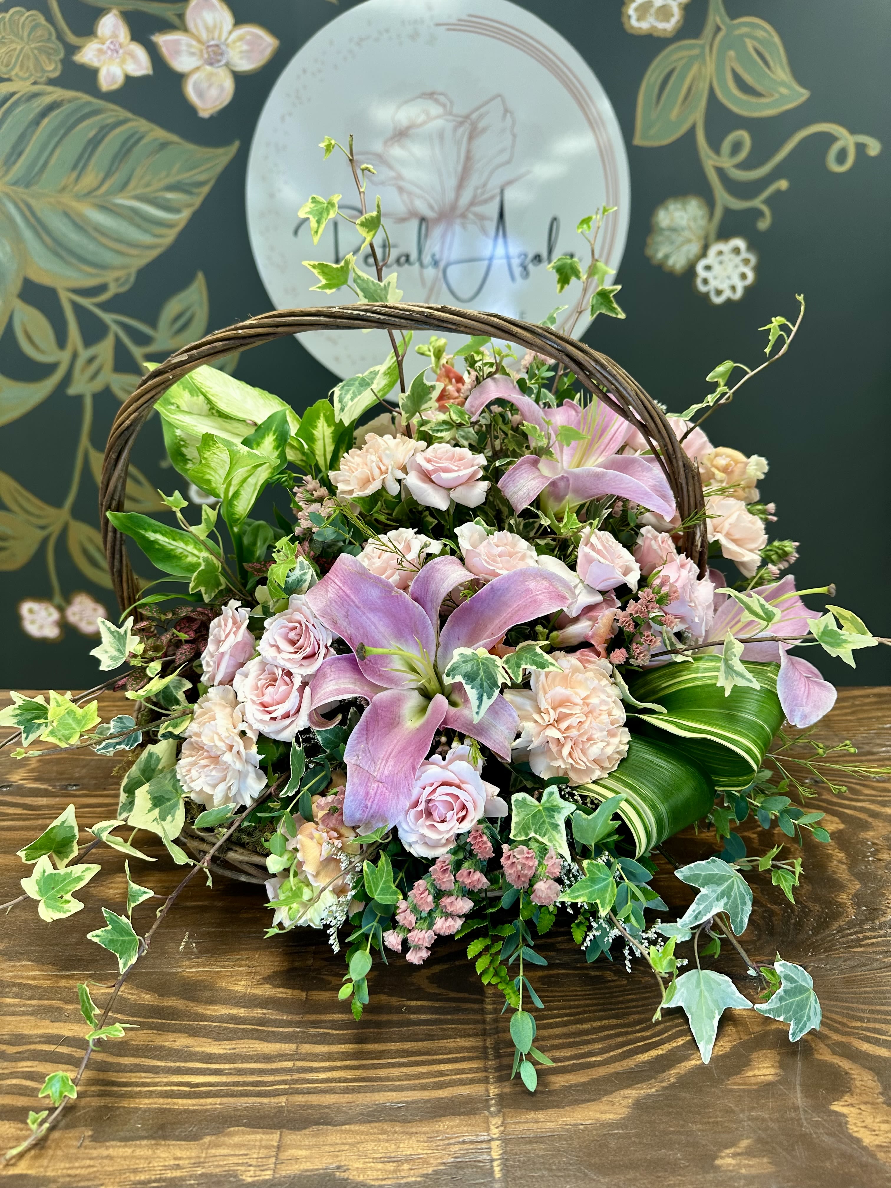Basket arrangement with pink lilies, roses, and carnations