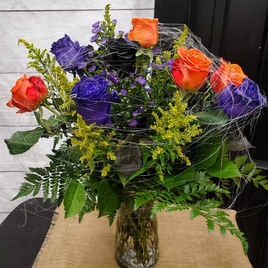 Bouquet of orange and purple roses in a glass vase