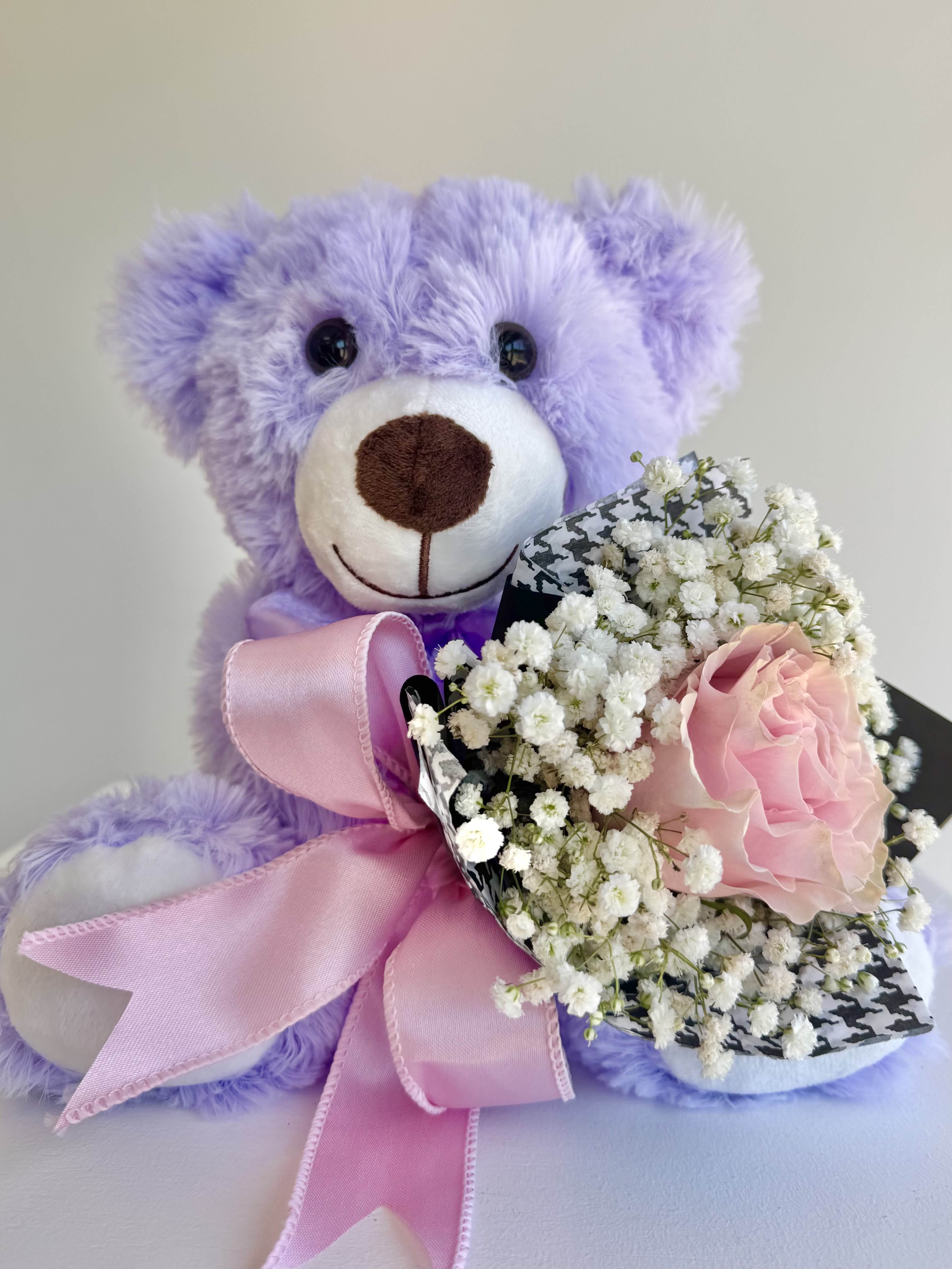 BEAR HUG BLOOMS - Sweet and charming, this  plush teddy bear is accompanied with a miniature wrap, filled with a single bloom and filler. This keepsake gift is perfect for birthdays, Get wells, graduation, or dance showcases! A beautiful combination of cuddly comfort  and fresh floral elegance that makes a lasting impression. 