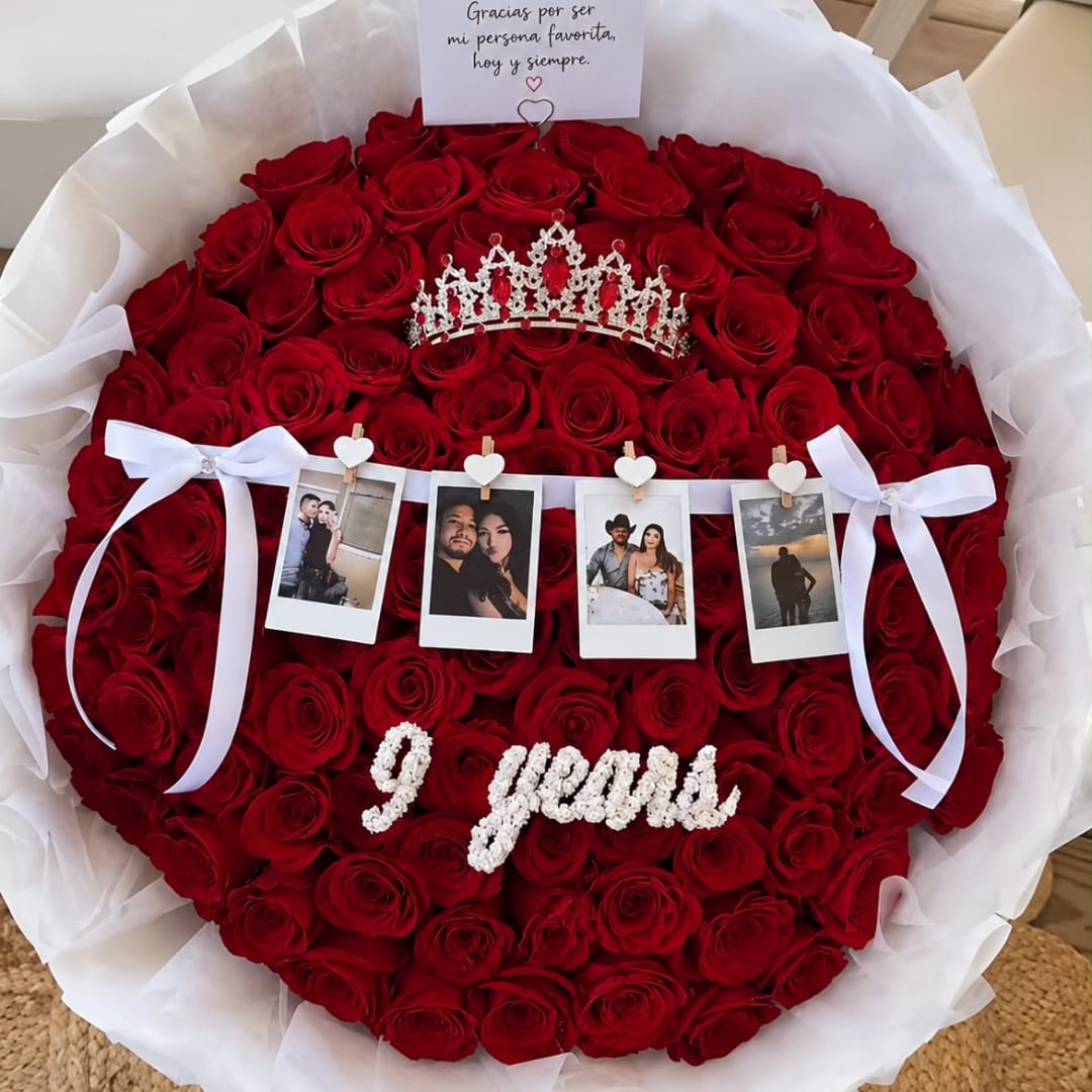 Round bouquet of red roses with a tiara, photo strip, and white ribbon