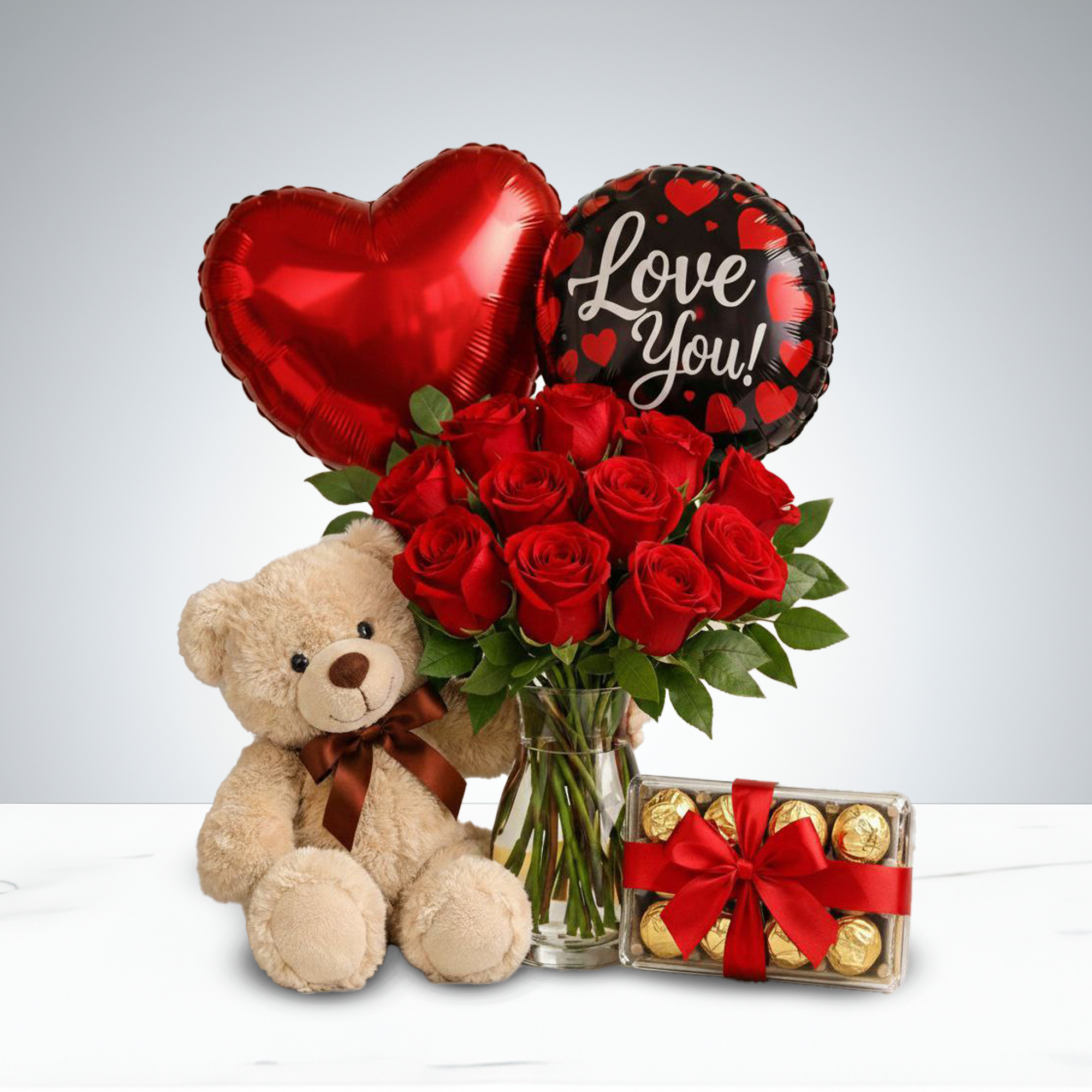 Cupid’s Deluxe Gift Set -   Sweep your loved one off their feet with this enchanting Valentine’s ensemble. Featuring a bouquet of radiant red roses in a clear glass vase, a plush teddy bear with a satin ribbon, two heart-shaped balloons that say “Love You!”, and a box of chocolates tied with a red bow, this set blends elegance, sweetness, and romance.