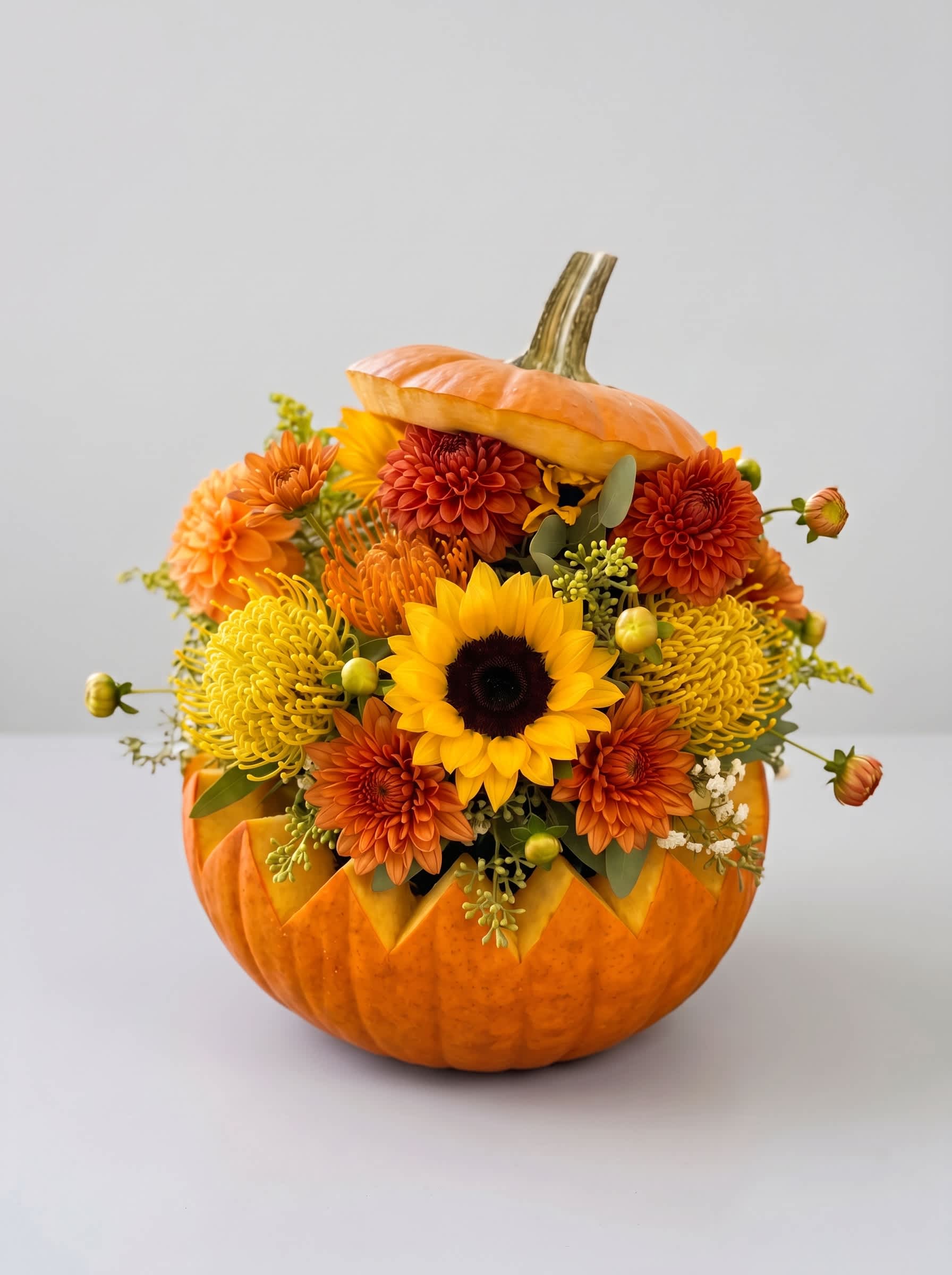 Orange pumpkin filled with yellow and orange flowers