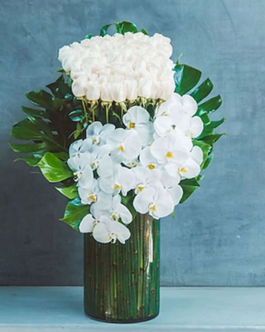 White Orchids and roses - White orchids and an amazing bunch of imported white roses arrange in a glass container
