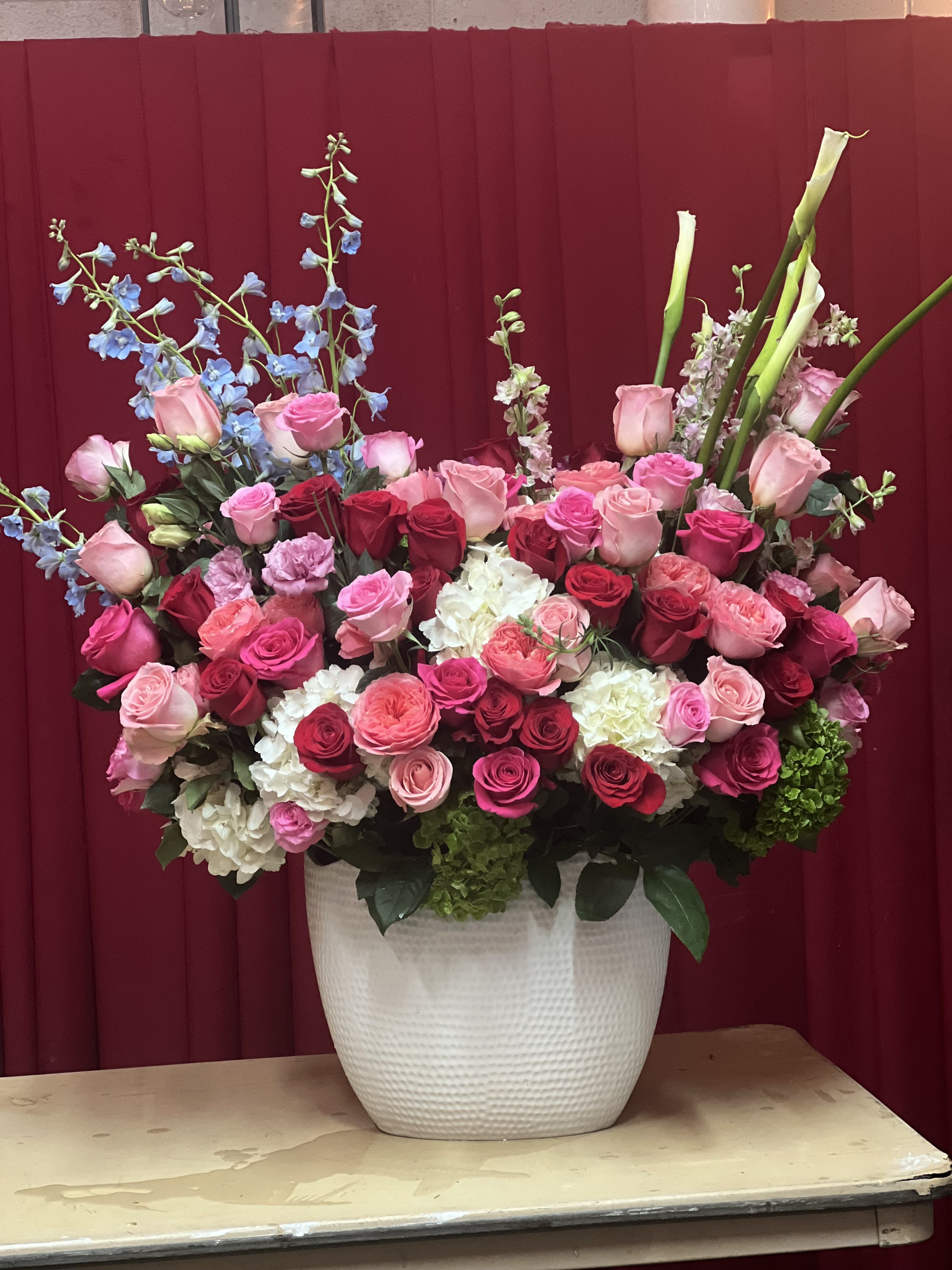 Large arrangement of pink and red roses in a white vase