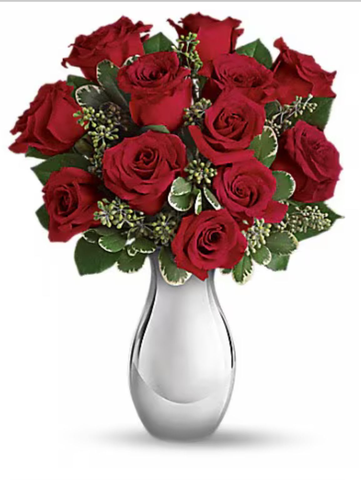 Red roses arranged in a clear glass vase