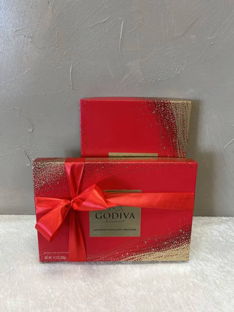 Two red Godiva chocolate gift boxes with a satin ribbon