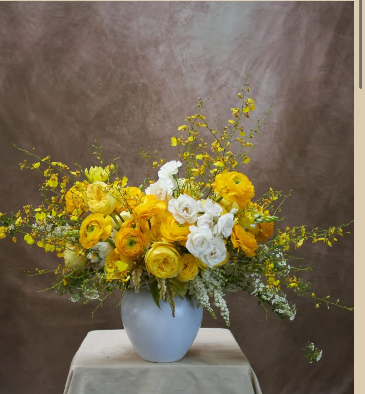 Yellow and white flower arrangement in a white vase