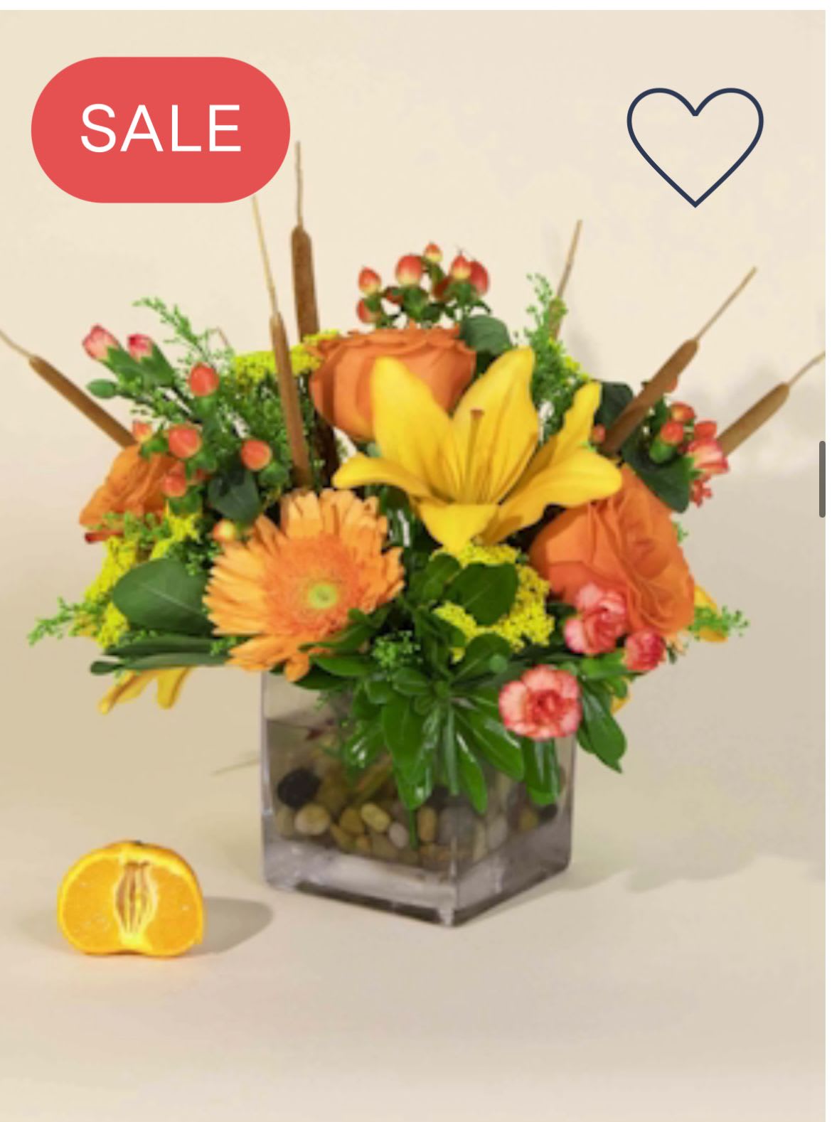 Orange and yellow floral arrangement in a square glass vase