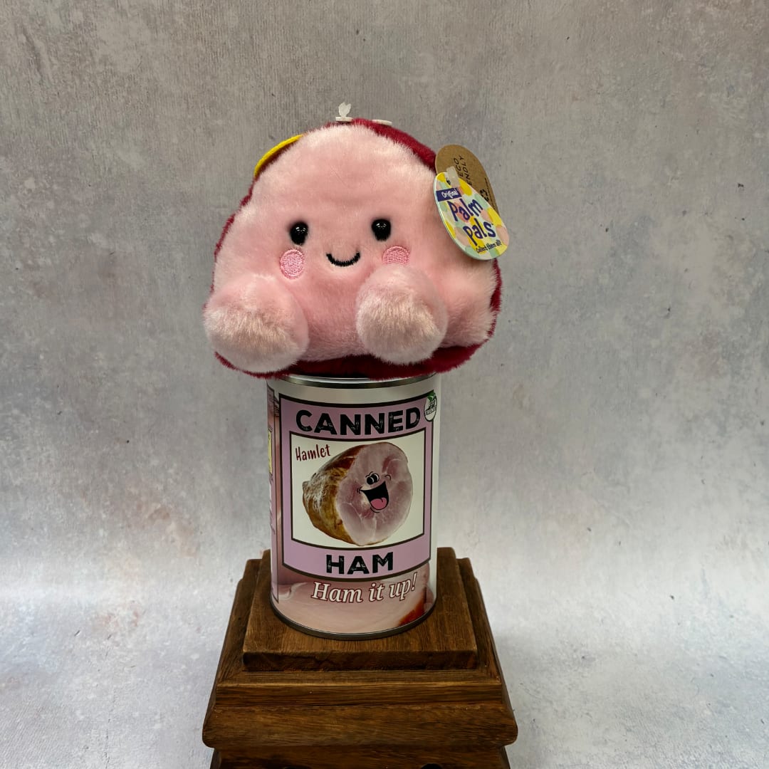 Plush pink toy sitting on a canned ham container