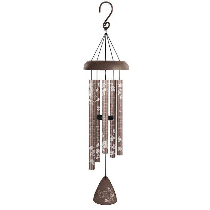 Brown metal wind chime with white floral patterns and inscription hanging from a hook