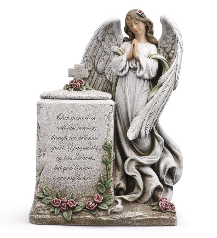 Angel memorial statue with praying figure beside stone block adorned with pink rose accents