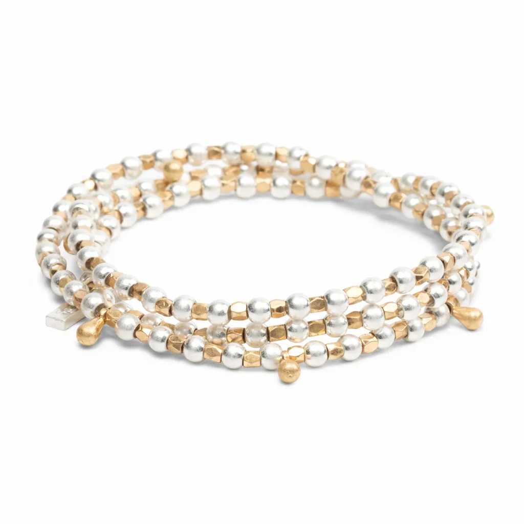 Gold and silver beaded wrap bracelet coiled in a circle on a white background