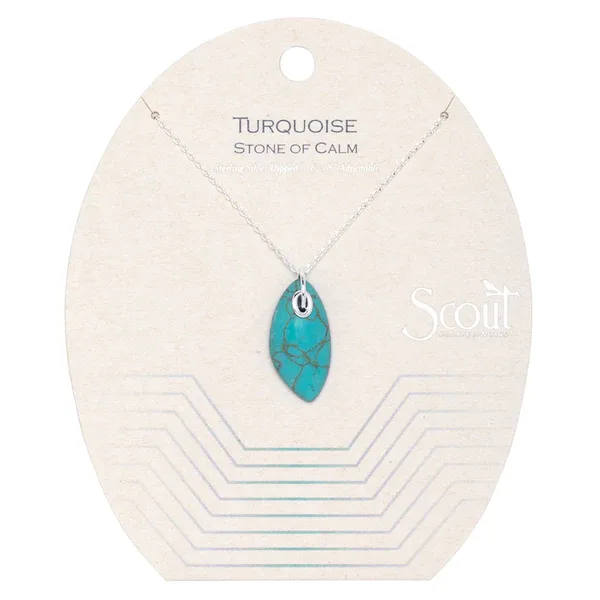 Turquoise stone pendant on a delicate silver chain displayed on a cream backing card.
