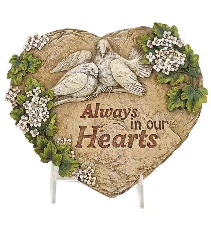 Heart-shaped memorial plaque with doves, small white blossoms, and the words Always in our Hearts.