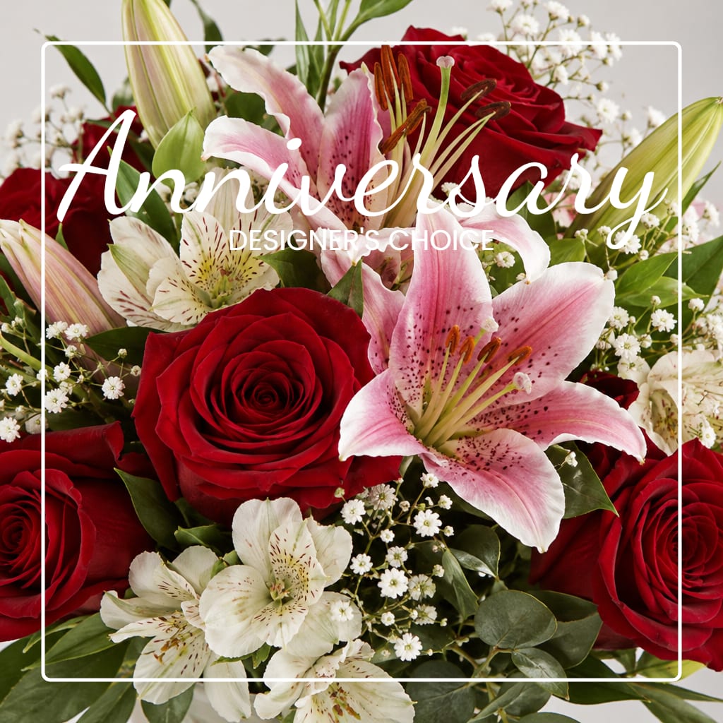 Red roses and pink lilies arranged with white filler flowers