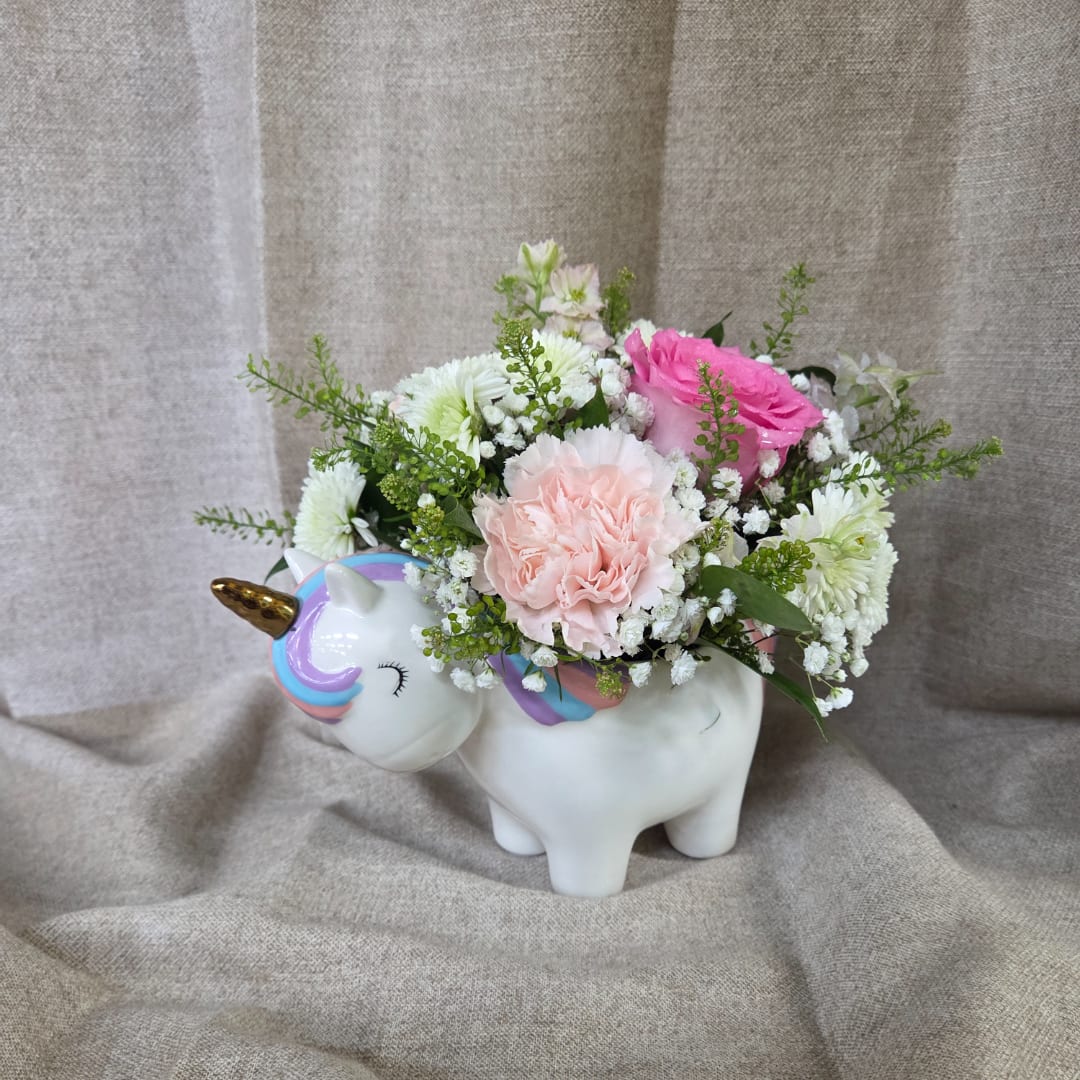 Pink and white flowers arranged in a unicorn-shaped ceramic planter
