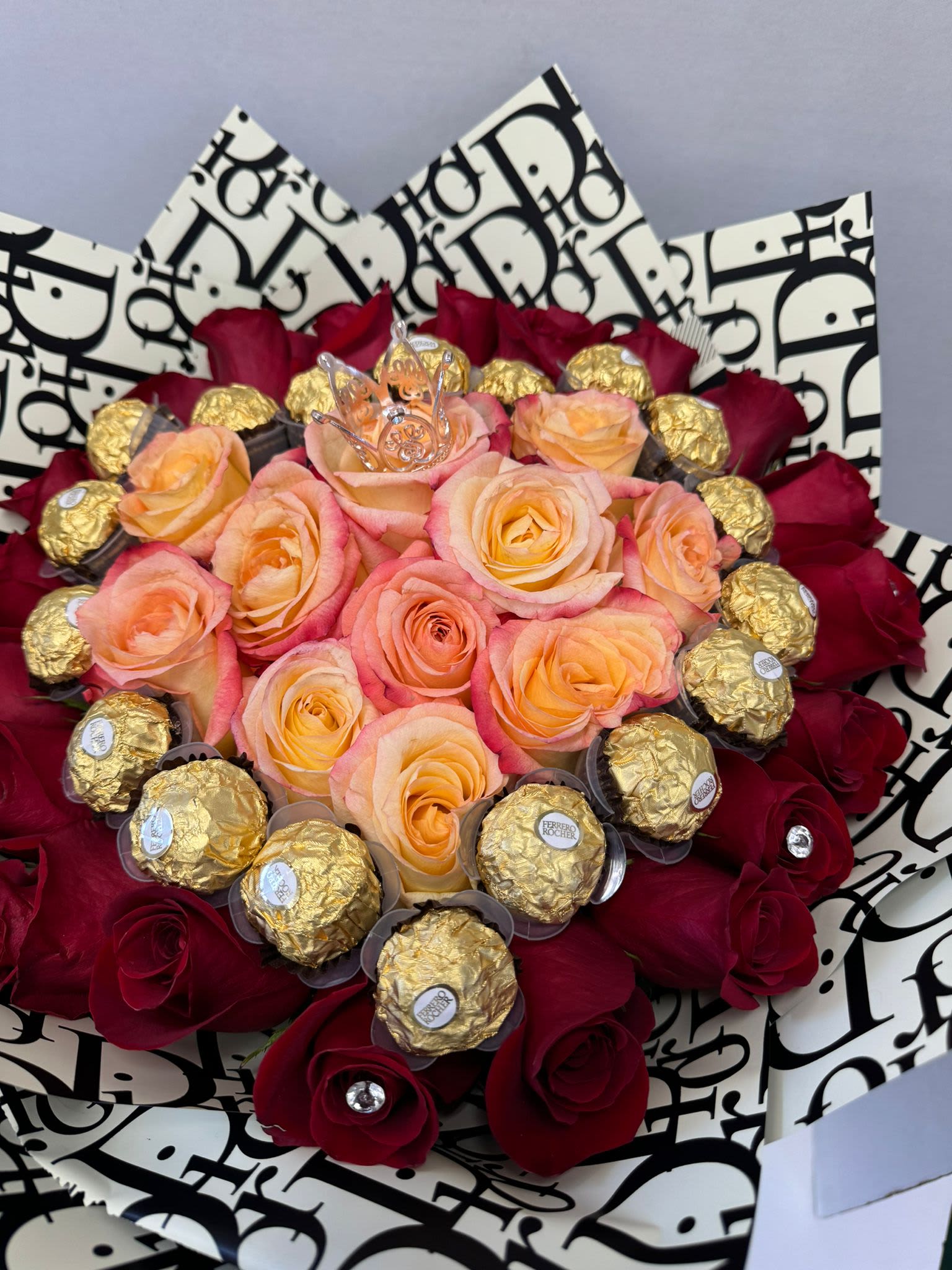 Bouquet of peach and red roses with gold-wrapped chocolates