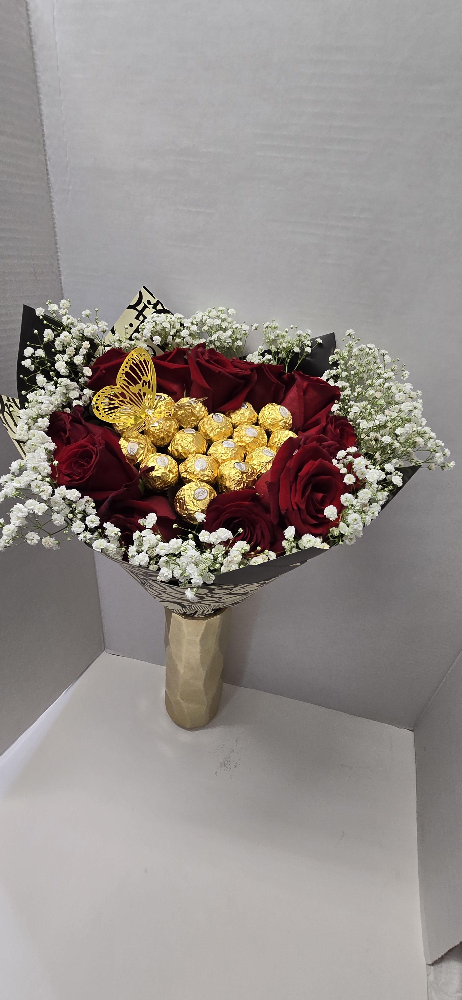 Bouquet of red roses with white baby's breath and gold chocolates