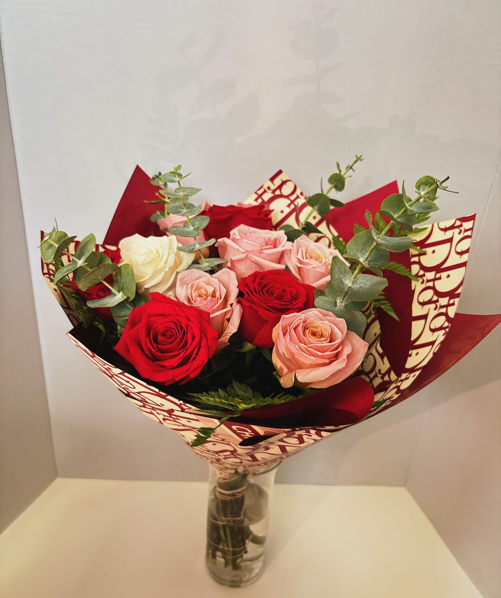 Bouquet of red, pink, and white roses in a glass vase