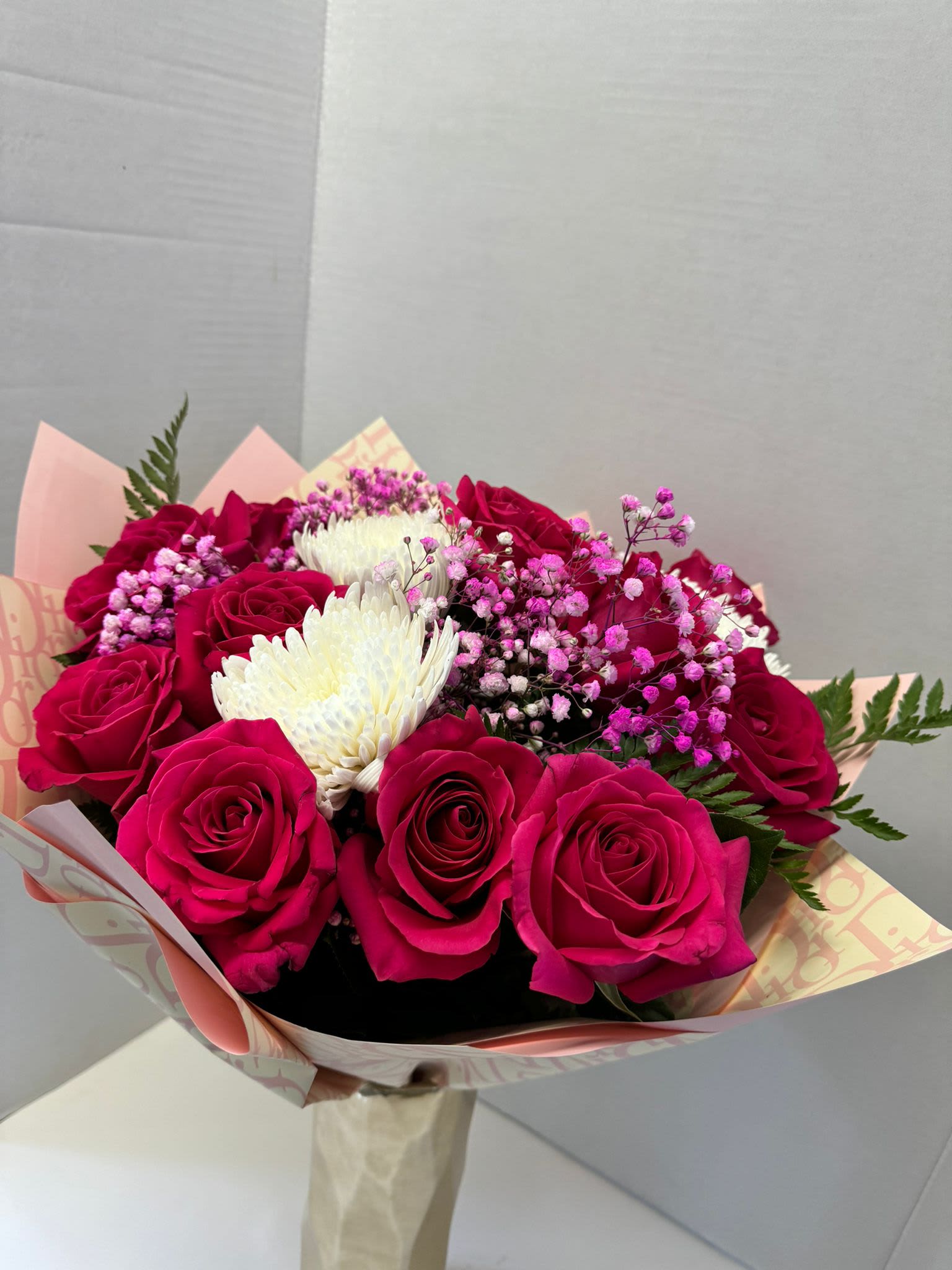 Bouquet of hot pink roses with white chrysanthemum blooms and pink baby's breath