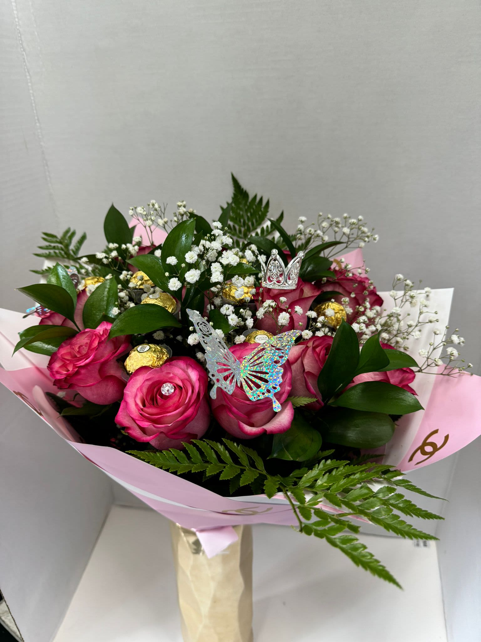 Pink rose bouquet with baby's breath, gold chocolates, and butterfly picks