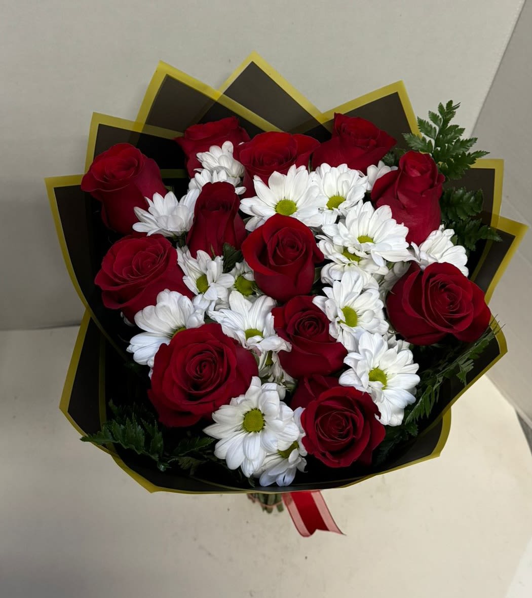 Bouquet of red roses and white daisies wrapped in black paper