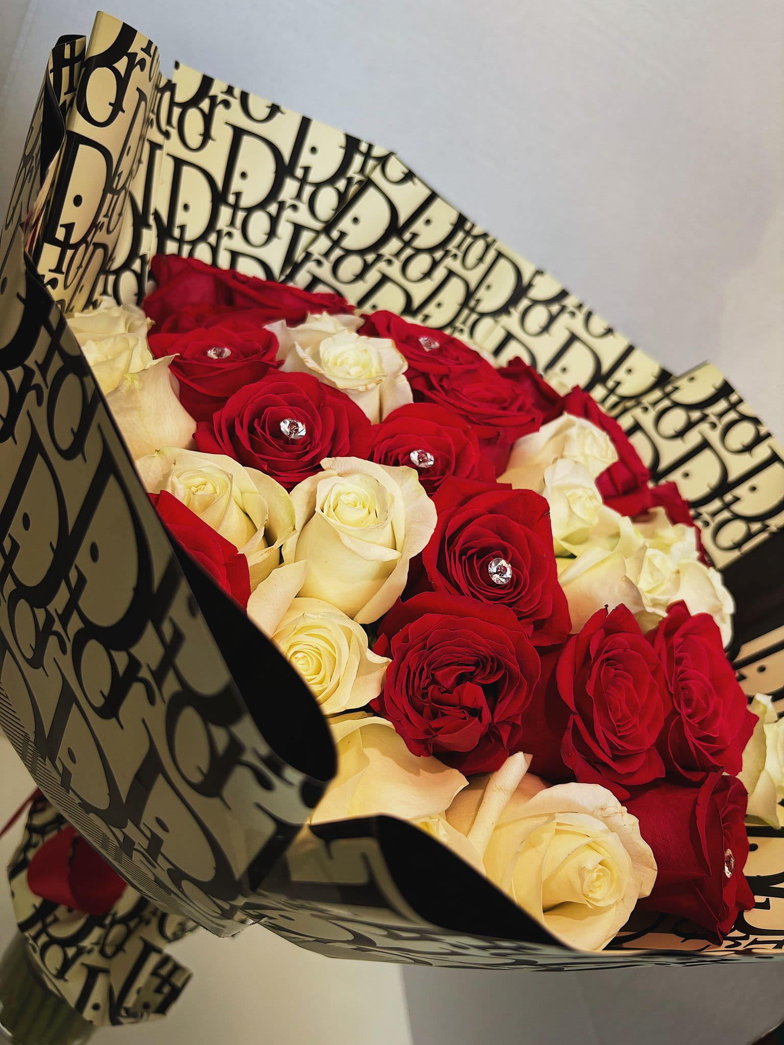 Bouquet of red and white roses wrapped in patterned paper