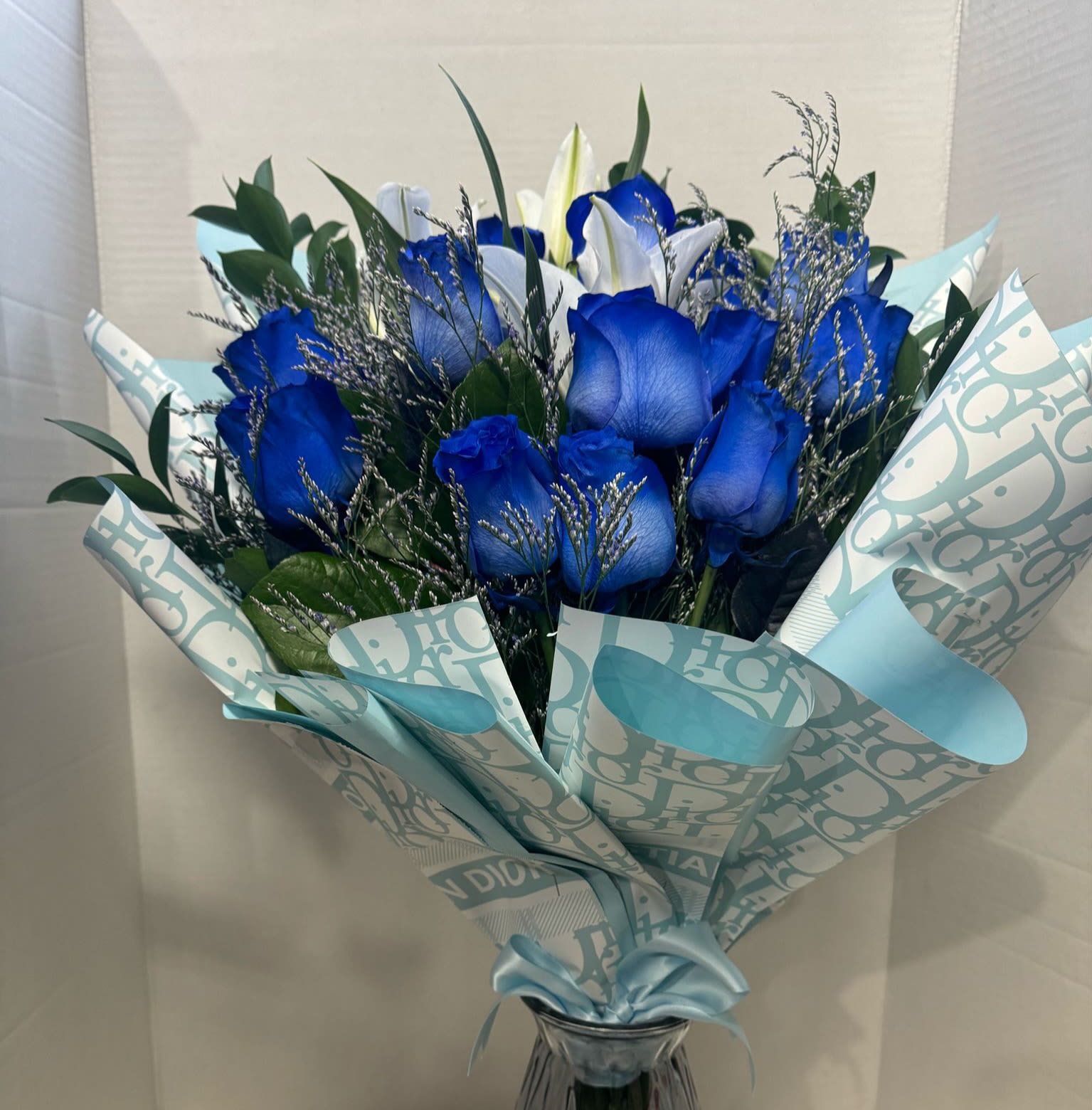 Blue roses and white lilies in a wrapped bouquet