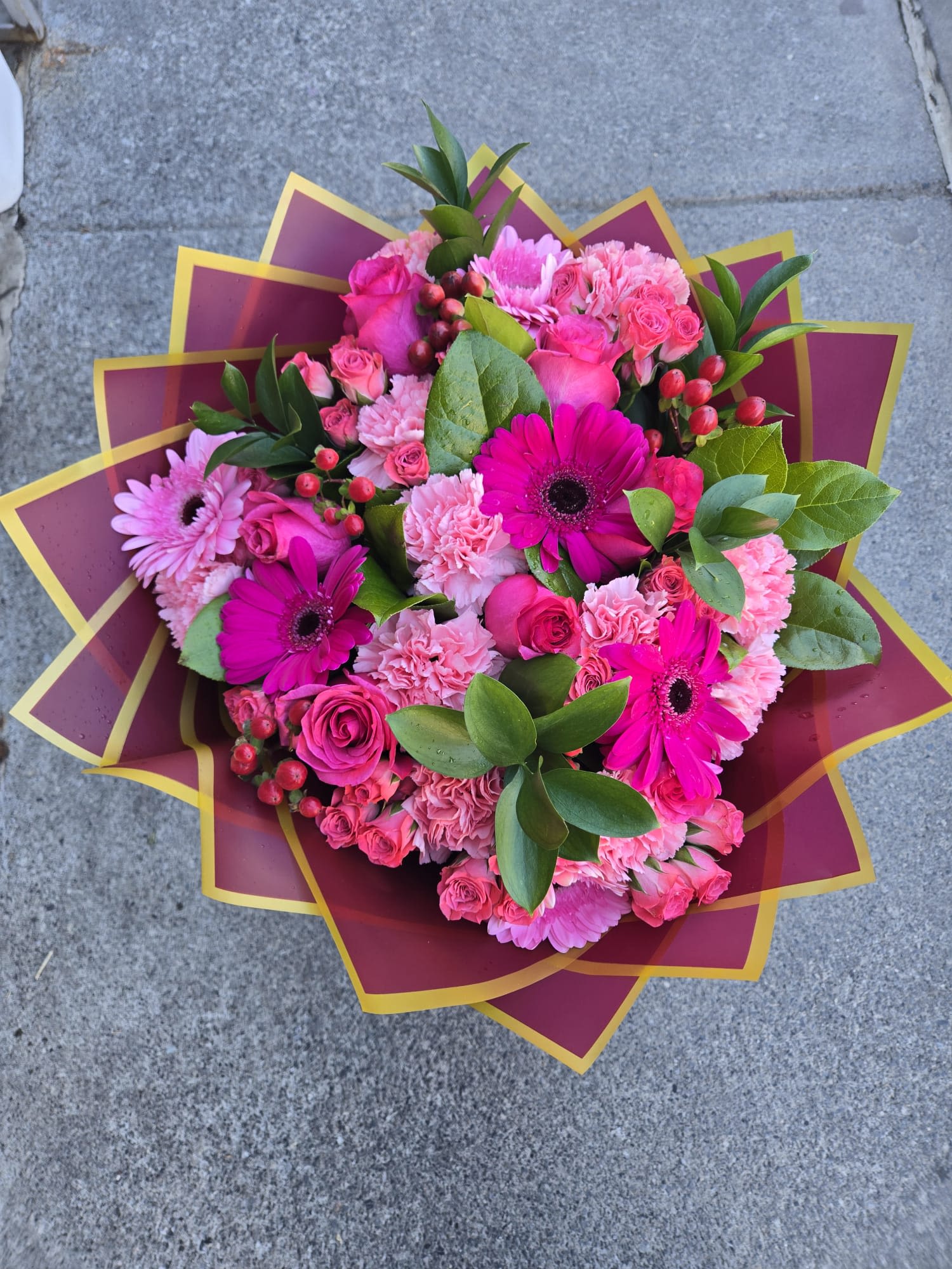 Pink bouquet with roses, gerbera daisies, and carnations in decorative wrap