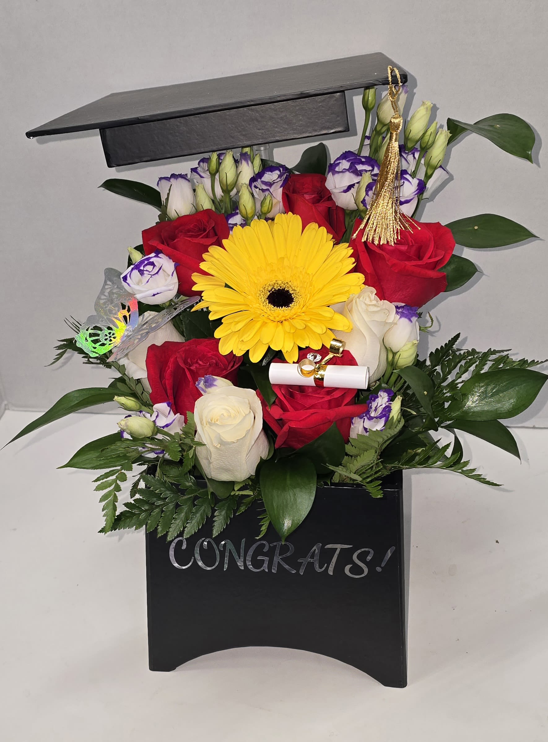 Graduation bouquet in a black box with roses and a yellow gerbera daisy