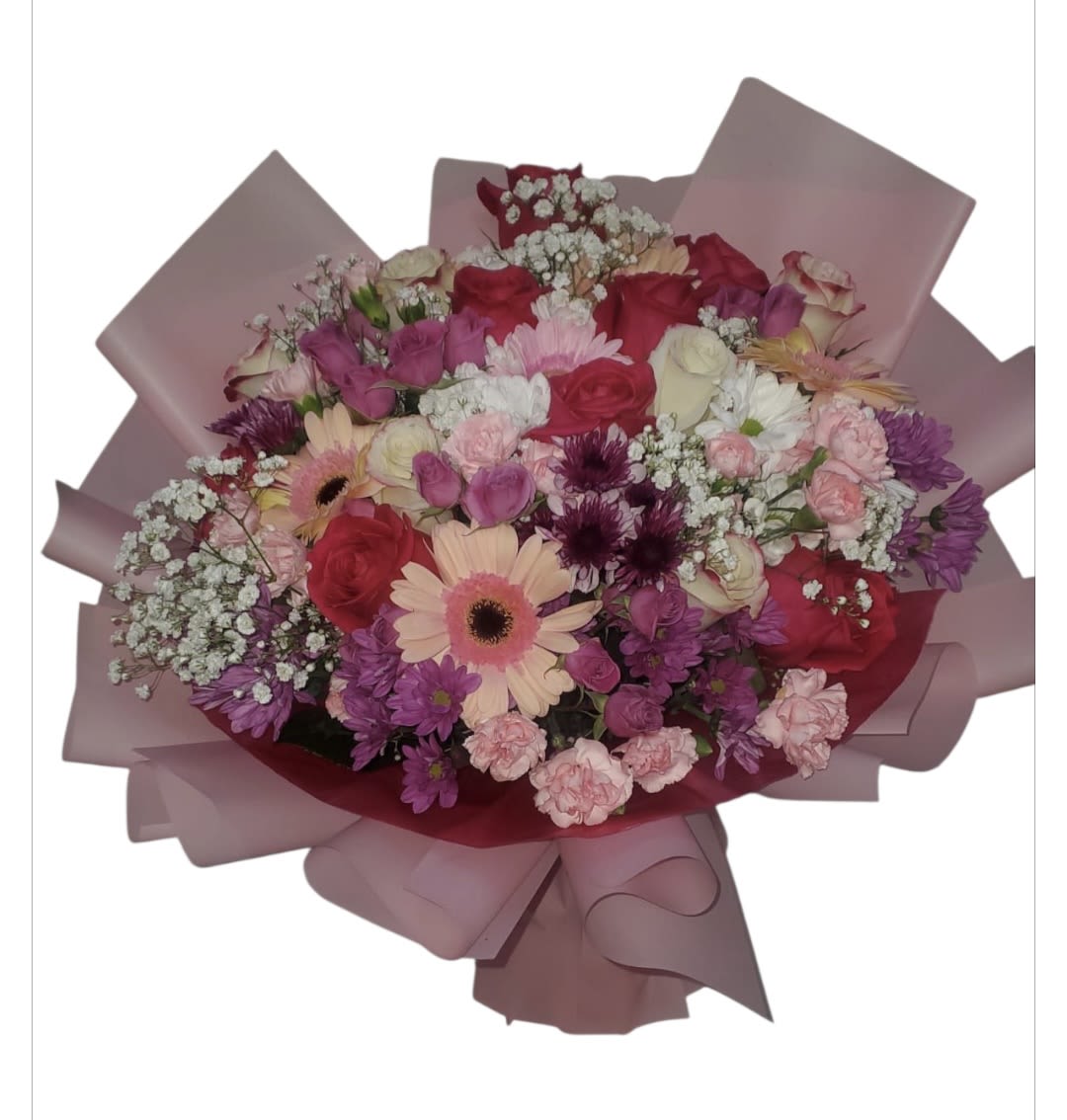 Mixed bouquet of pink, purple, and white flowers wrapped in pink paper