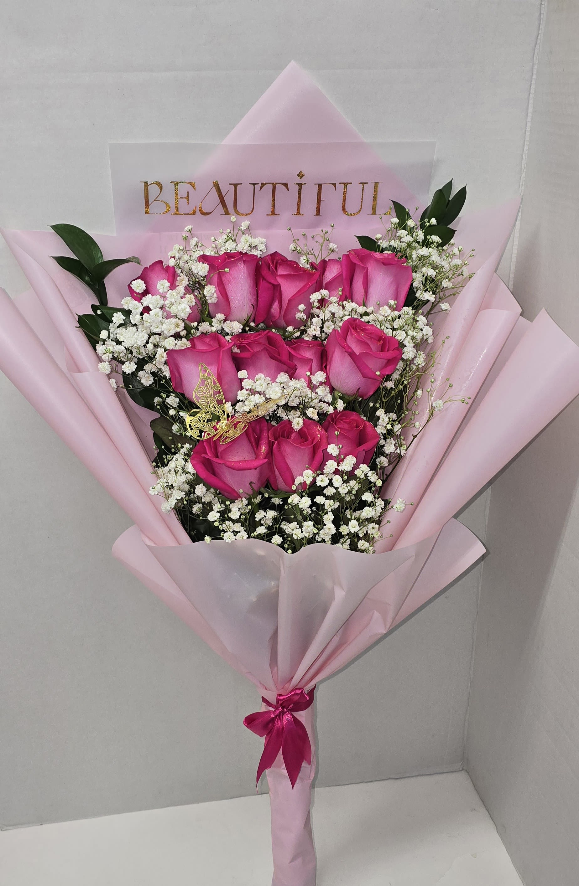 Bouquet of pink roses with baby's breath in pink wrapping
