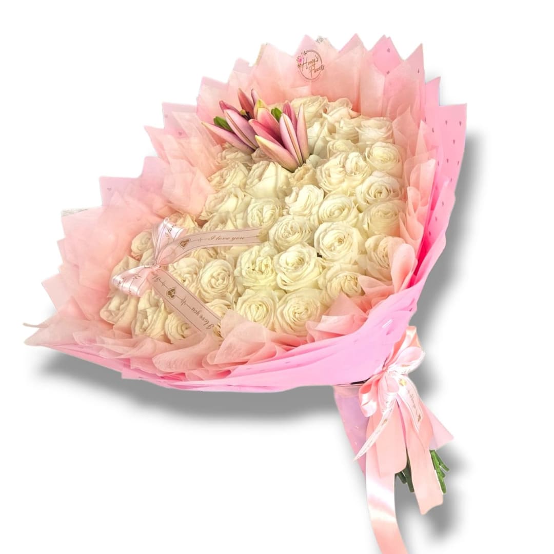 Bouquet of cream roses wrapped in pink paper with a ribbon