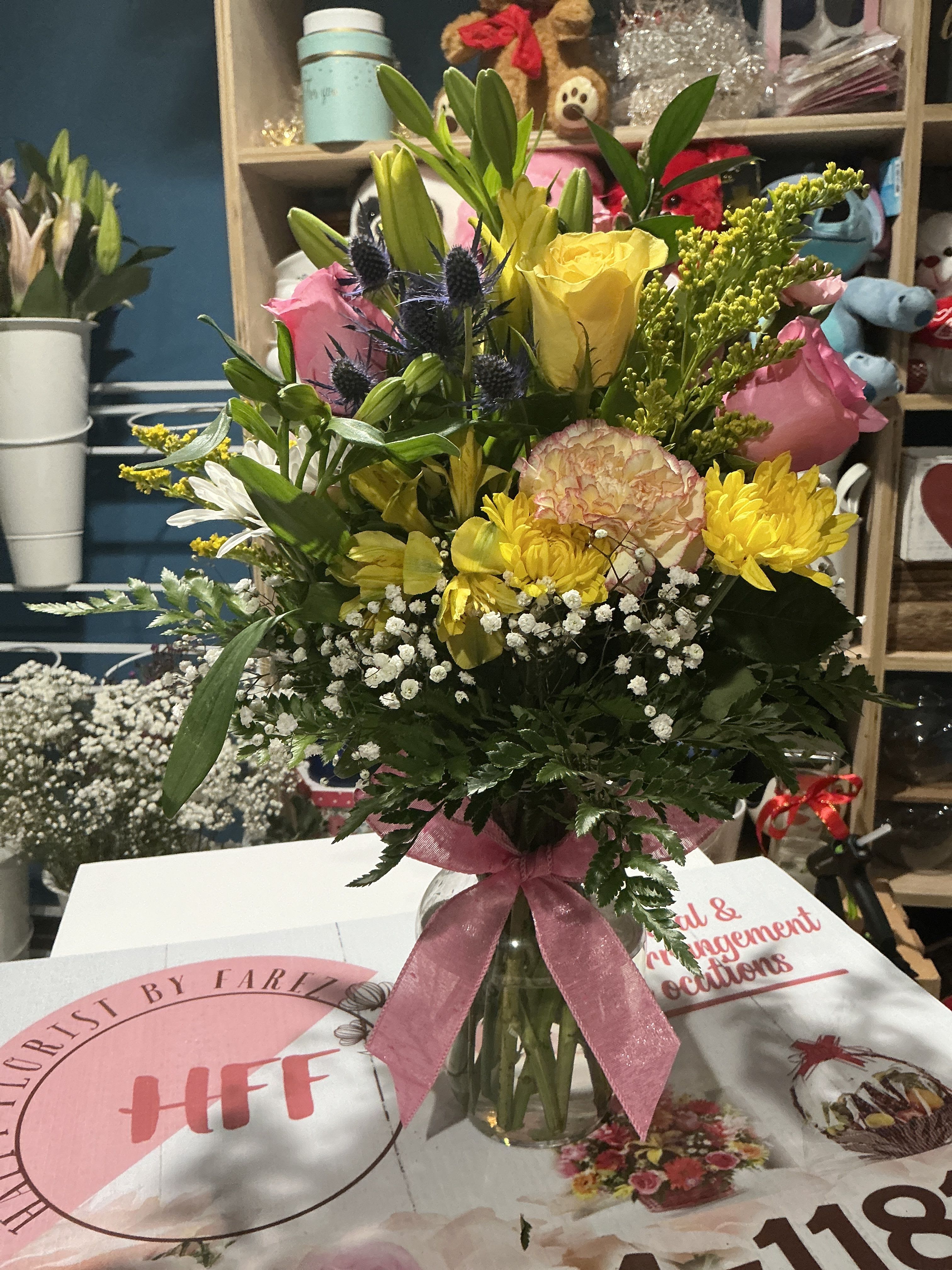 Smile  - This floral arrangement between yellow and pink brings joy to your day perfect gift for woman day birthday and other ocasión   Contains   Roses Chrysanthemums carnations stock Lili astromelia solidago greenery glass vase  21H 13W