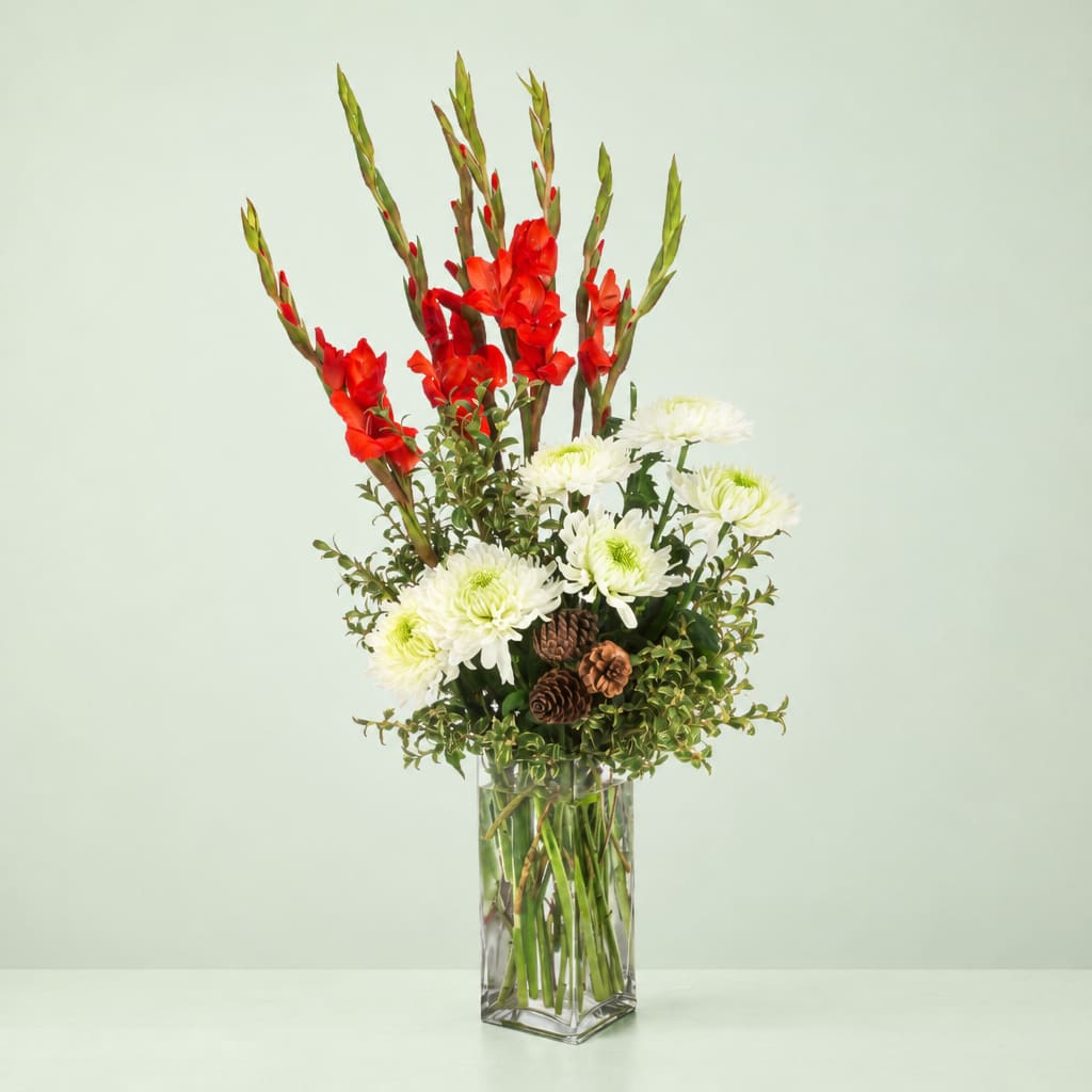 Red gladiolus and white chrysanthemums in a clear glass vase