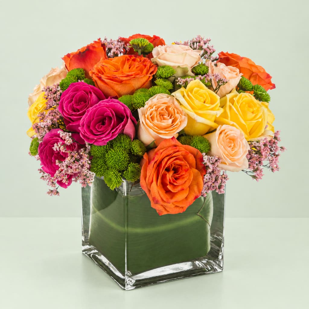 Colorful rose bouquet in a clear square vase
