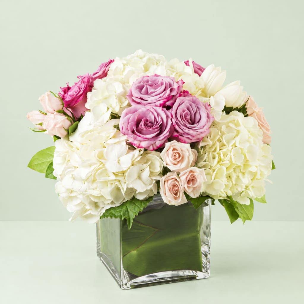 Pink roses and white hydrangeas in a clear square vase